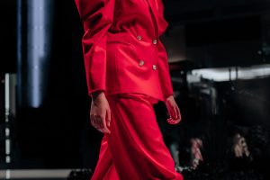 Cropped female figure dressed in classic red pants and jacket co